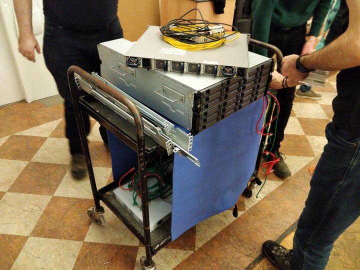 Switch, NetApp controller and disks, rails, and assorted cables on a trolley